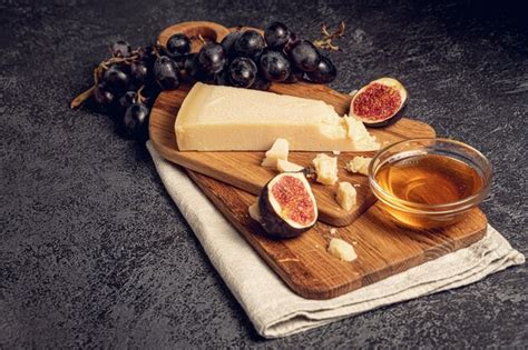 Plato de Parmigiano Reggiano en trozos con frutas, miel y vinagre balsámico