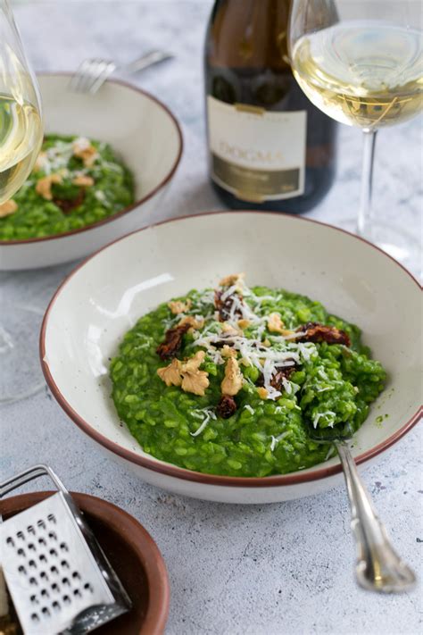 Plato de risotto de espinacas y nueces listo para servir, con una textura cremosa y un color verde vibrante