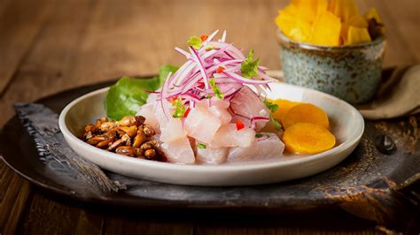 Fotografía gastronómica de un ceviche fresco servido con zarandaja y chifles en la costa trujillana