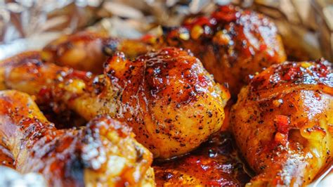 Detalle del pollo siendo glaseado con la mezcla de miel y limón en la barbacoa