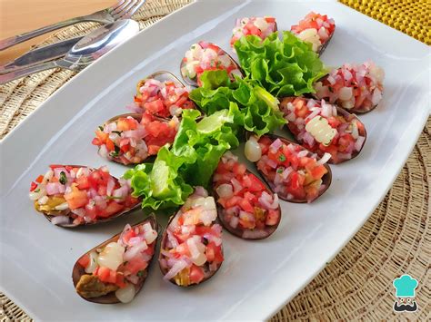 Plato servido de choritos a la chalaca en su concha, con el aderezo criollo encima.
