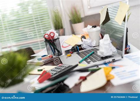 Imagen de un escritorio desordenado con papeles y libros.