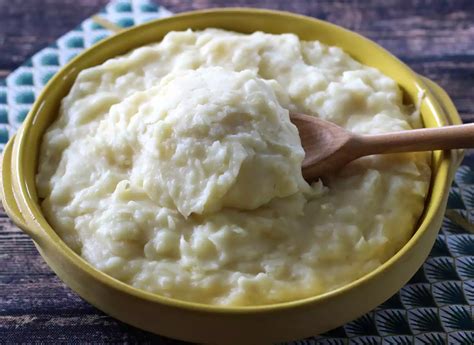 Un plato de puré de yuca cremoso con trozos de queso derretido.