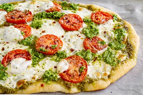 pizza casera al pesto con tomates cherry y mozzarella