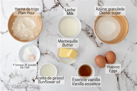 Mesa con ingredientes para hornear cupcakes: harina, azúcar, huevos, mantequilla, leche, vainilla y polvo para hornear.