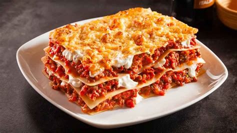 Una porción generosa de lasaña recién horneada, con queso gratinado.