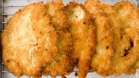 Proceso de empanado de los filetes de pollo, mostrando el orden de harina, huevo y pan rallado.