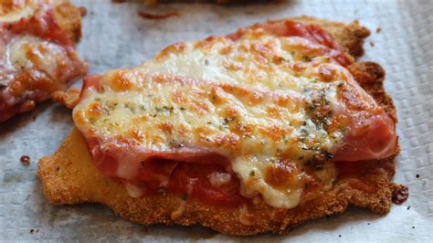 Milanesa de pollo napolitana terminada, con el queso fundido y dorado.