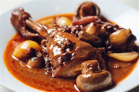 Plato de pollo al vino con morillas en una cazuela de cobre