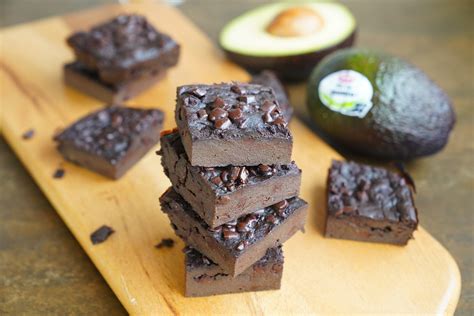 Una imagen de un brownie de aguacate cortado, mostrando su textura cremosa y trozos de nuez.