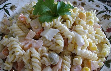 Ensalada de fideos cremosa con mayonesa y crema de leche, decorada con hierbas frescas