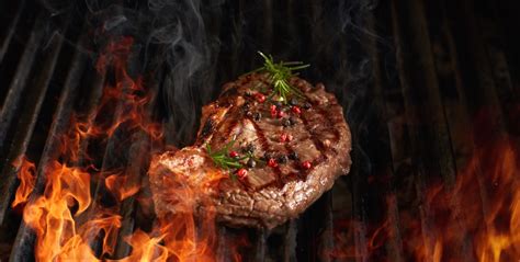 Foto de un bife de chorizo a la parrilla, humeante y jugoso