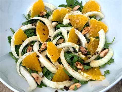 ensalada colorida de hinojo, rúcula y naranja, con trozos de manzana y queso opcional
