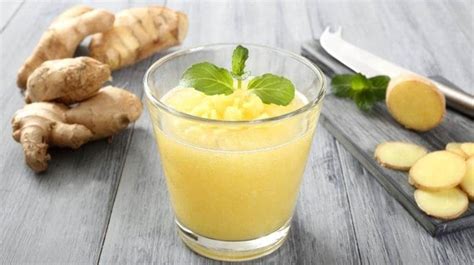 Una licuadora con los ingredientes de la piña, jengibre y agua, en proceso de triturado.