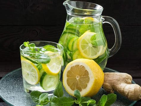 Vasos de limonada de piña, menta y jengibre servidos con hielo, rodajas de limón y hojas de menta, listos para disfrutar.