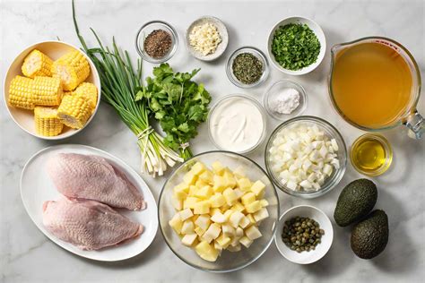 Variedad de ingredientes frescos para ajiaco cubano, incluyendo trozos de cerdo