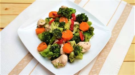 Plato de pollo al horno con brócoli, zanahoria y coliflor, guarniciones y hierbas aromáticas