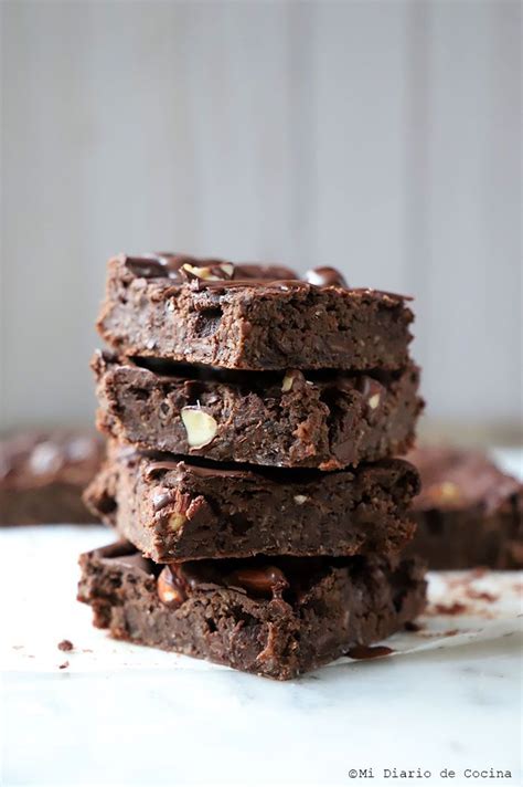 Fotografía cenital de brownies de porotos negros con textura húmeda y trozos de nueces