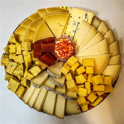 Fotografía de la heladera de quesos intervenidos en La Tablita con variedad de colores y toppings
