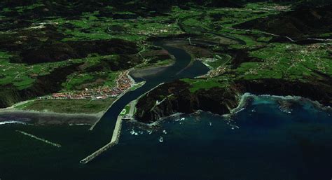 Vista panorámica de Caleta Manzano con la desembocadura del río y la playa de arena blanca.