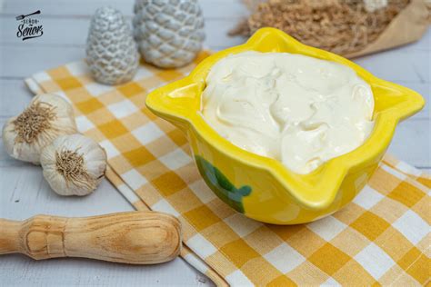 Preparación de alioli casero en mortero, mostrando el proceso de machacado de ajos y emulsión con aceite