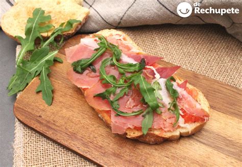 Imagen de una tosta de jamón serrano y uvas sobre una base de queso.