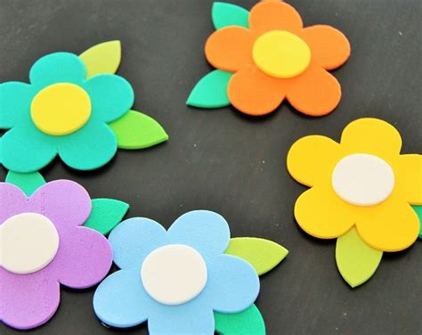 Suministros para manualidades de flores de goma EVA, incluyendo planchas de goma EVA de colores, tijeras, pegamento y palitos de brocheta.