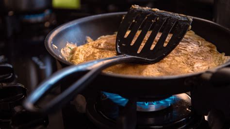Fotografía de un bizcocho cocinándose en una sartén tapada a fuego bajo