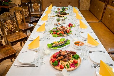 Fotografía de una mesa servida con diversos tipos de meze tradicionales y pescado fresco frente al mar.