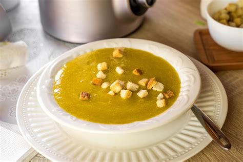fotografía de un plato humeante de crema de porotos con crutones y hierbas frescas