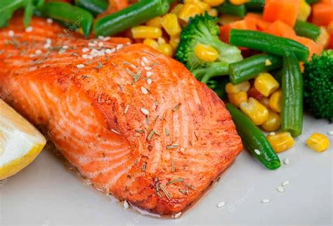 filete de salmón jugoso sobre una cama de verduras asadas