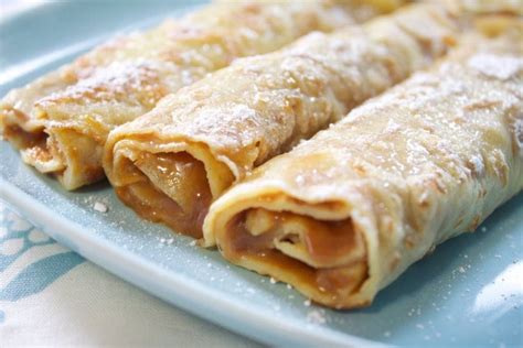 Fotografía de panqueques rellenos de manjar espolvoreados con azúcar flor