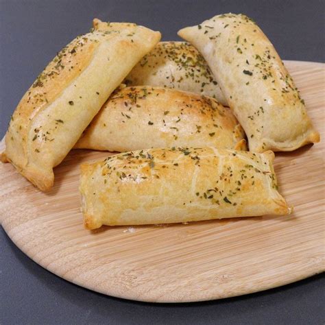 Imagen de chaparritas doradas recién salidas del horno, mostrando la textura crujiente de la masa y el relleno de longaniza.