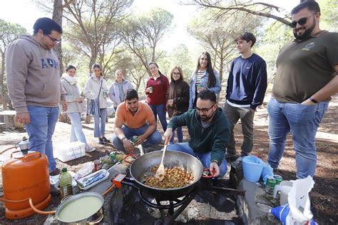 Un grupo de amigos preparando un perol cordobés al aire libre.