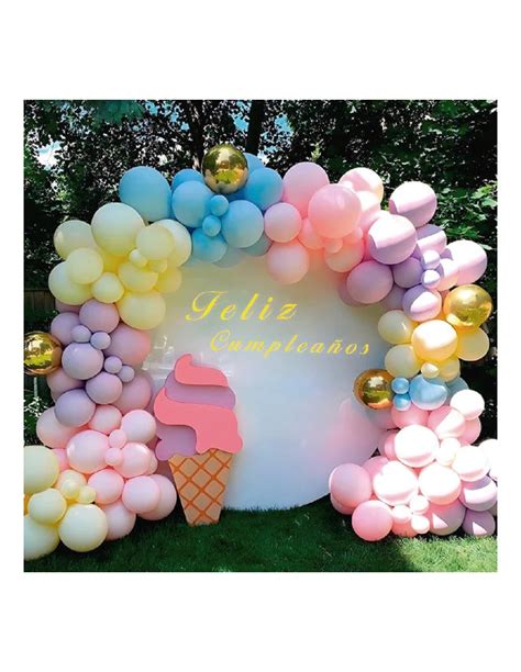Esquema de un arco de globos orgánico de colores pastel posicionado detrás de una mesa de dulces, destacando el punto focal central