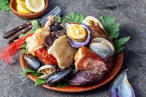 Fotografía de un plato de curanto recién servido con mariscos, carnes y milcaos