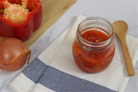 Fotografía gastronómica de un frasco de chutney de pimiento rojo artesanal