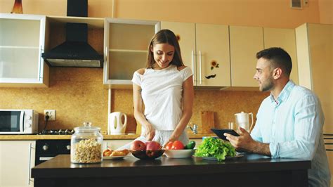 Pareja preparando sushi juntos en una cocina romántica