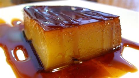 Fotografía cenital de un tocino de cielo desmoldado con caramelo brillante sobre un plato blanco