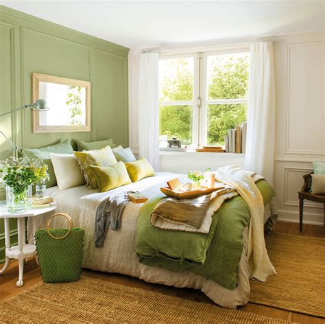Habitación decorada en tonos marfil con muebles de madera clara y acentos verdes