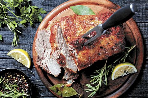 Primer plano de paleta de cerdo asada con hierbas y salsa