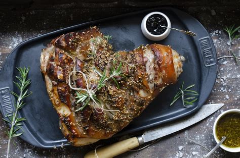 Plato de paleta de cerdo asada con patatas y peras, con salsa