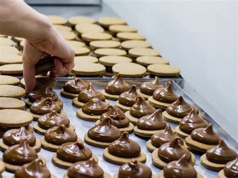 Proceso de armado de alfajores: untar relleno, unir galletas y decorar con coco rallado.