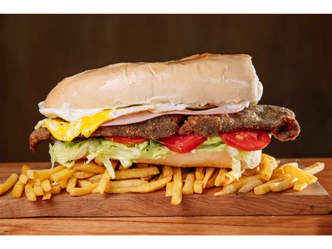 Sándwich de milanesa con papas fritas y aderezos