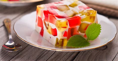 Ilustración de cubos de gelatina de colores con trozos de fruta.