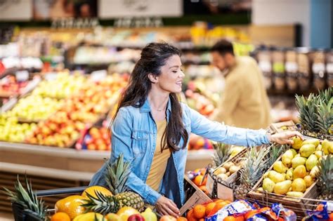 Imagen de una persona eligiendo frutas y verduras frescas en una feria libre.