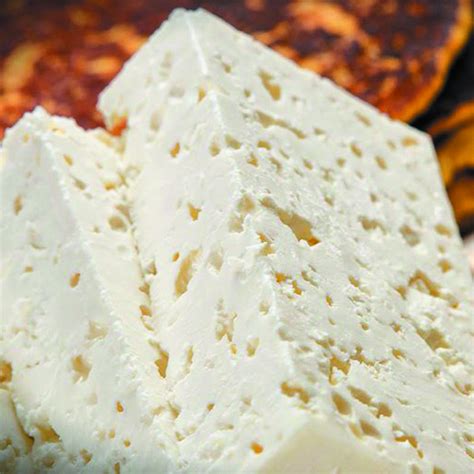 Mano cortando una sección mohosa de un queso duro para salvar el resto