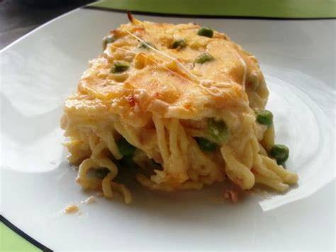 Fotografía gastronómica de una fuente de tallarines al horno con capas doradas y relleno visible.