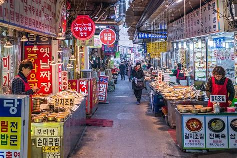 Viajera explorando mercados de comida callejera en Corea con notas veganas