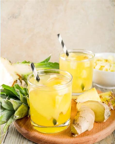 Vaso de agua de piña con jengibre y menta, decorado con rodaja de limón y hojas de menta